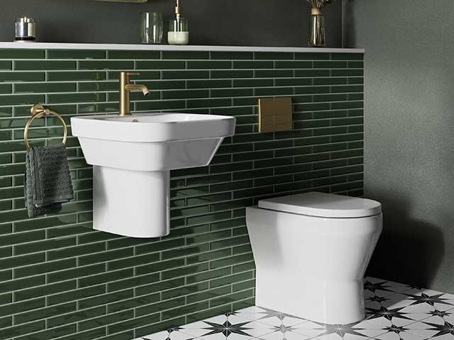 Green tiled bathroom with starry feature flooring and white units