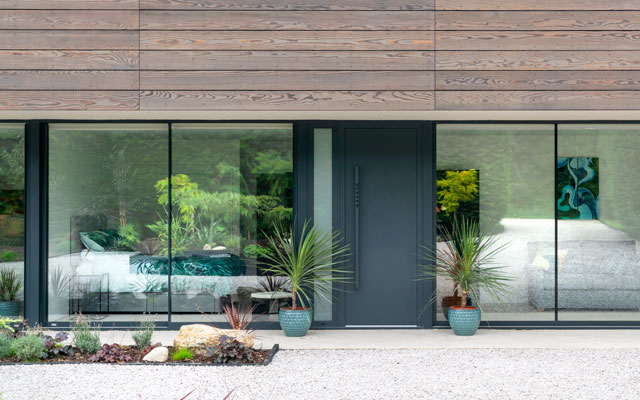 The front entrance of a pavillion-style home with the front door flanked by glazed panels