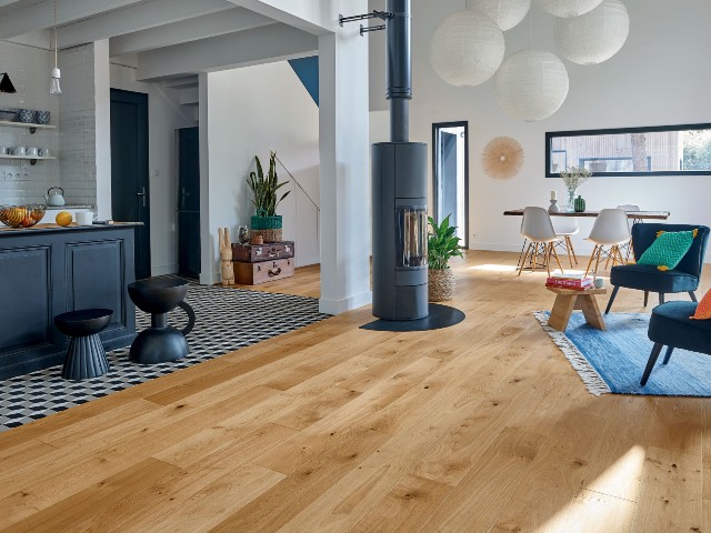 hardwood flooring in a modern open-plan home with wood burning stove and modern kitchen