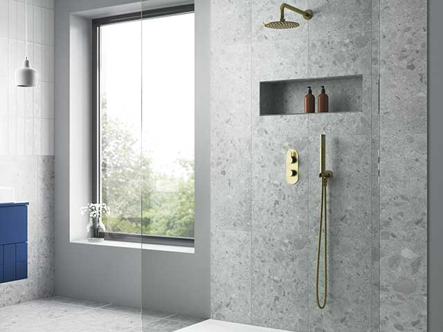 Marble shower with gold showerhead and taps and large full length window