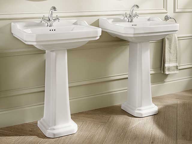 Two white sinks with silver taps in bathroom with cream panelled wall