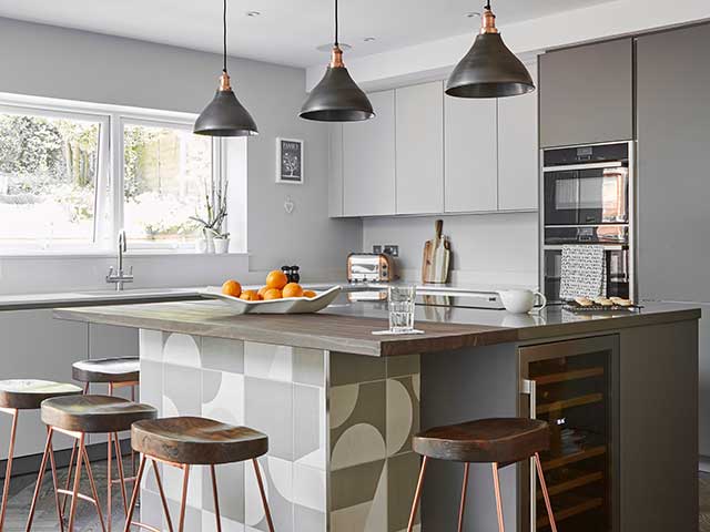 Cone pendants in pewter and copper above a kitchen island lend an industrial chic vibe