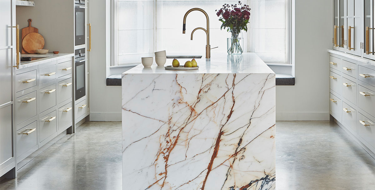 how to plan a kitchen island: this marble kitchen island was planned in at design stage