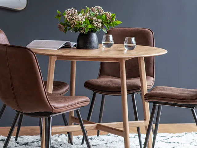 round oak dining table with leather-look chairs and blue grey walls