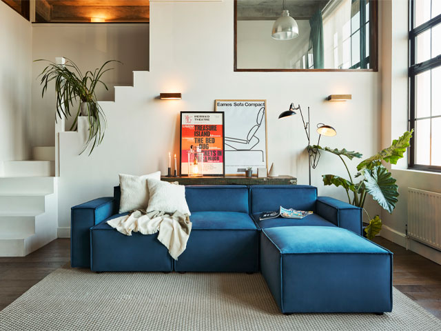 blue modular corner sofa with ottoman in a modern apartment