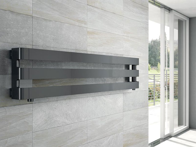 minimalist radiator in grey on a tiled wall in a contemporary house