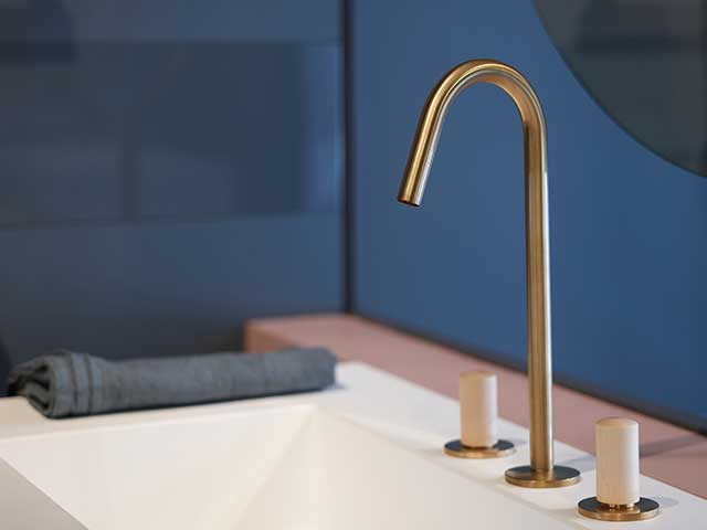 modern bathroom with blue walls, gold fittings and white porcelain sink