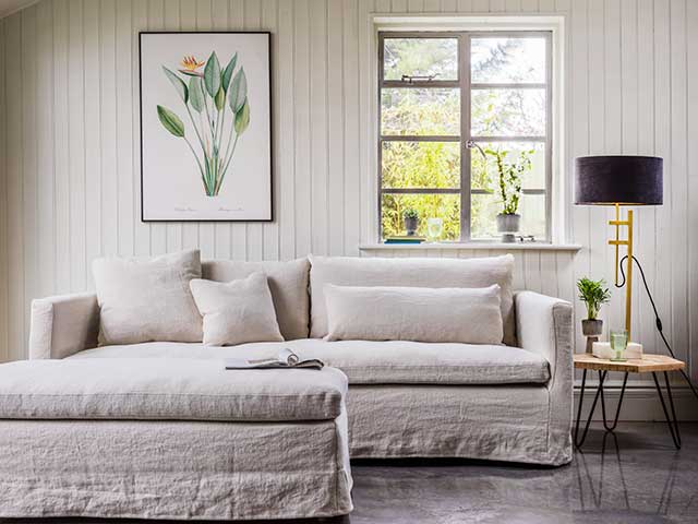 Cream wood framed sofa in panelled living room