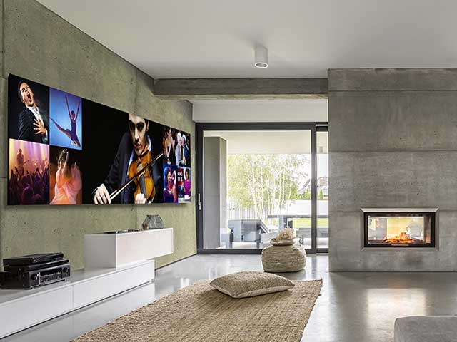 Futuristic 325 inch cutom-installed TV in spacious living room with bifold doors