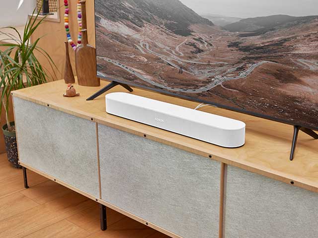 Seamless fitting multi-room audio system with soundbar on wooden floor