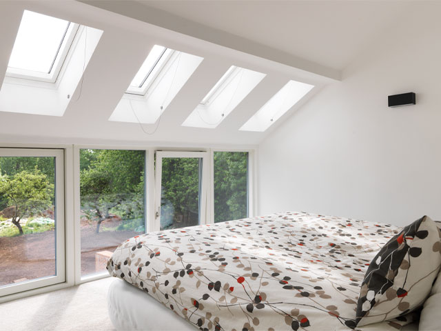 contemporary bedroom with floor-to-ceiling windows and garden views