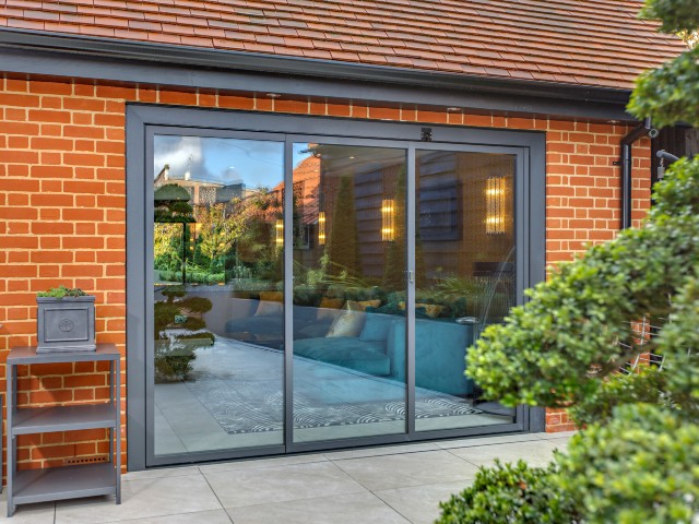 closed slide and turn doors with three panes of glass on a red brick house