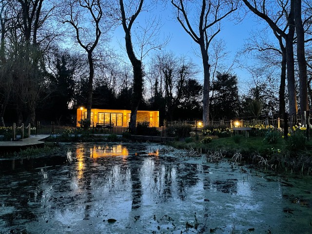 large insulated garden office overlooking a frozen pond in winter 