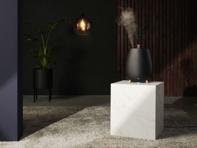 compact humidifier in black on a white plinth in a modern apartment