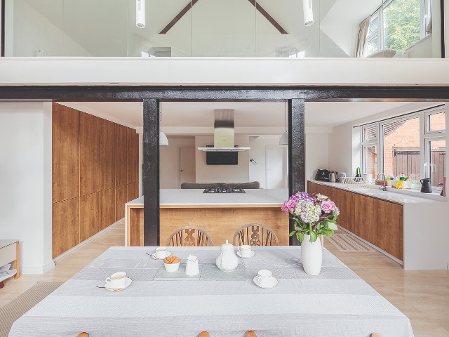 wide open-plan kitchen and dining space with steel beam and natural materials
