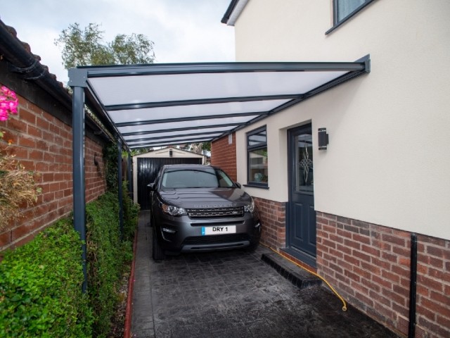 a carport attached to the side of a red brick house