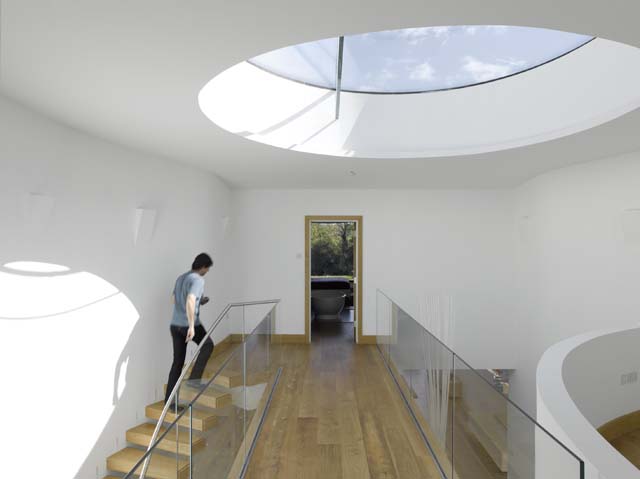 The entrance is in the middle of the house under a circular atrium to let in light
