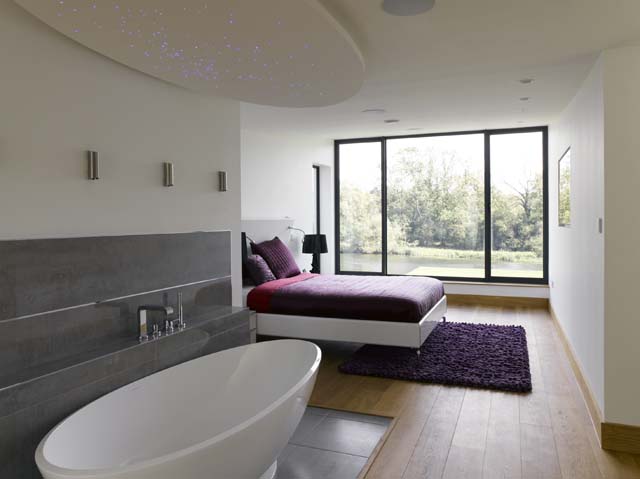 The master bedroom suite with river views and freestanding bath in the bedroom. Thames house Oxfordshire