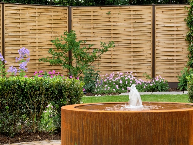 fencing ideas: woven wood slats in natural finish with contrasting steel fence posts