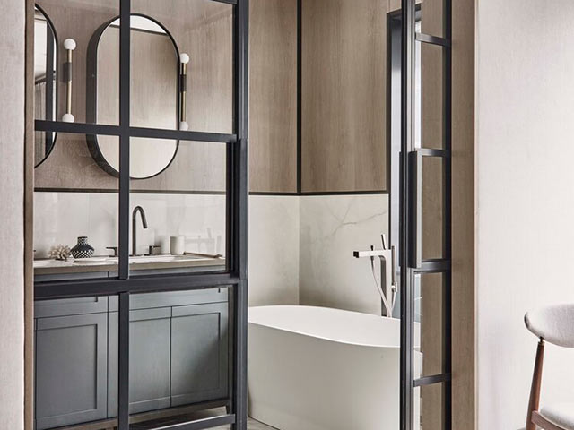 En-suite bathroom ideas: glass bifold doors leading to freestanding bath and basin