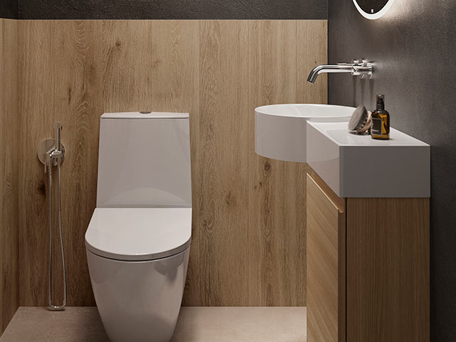 compact loo in an en-suite bathroom with white fittings, wooden panelling and concrete effect walls