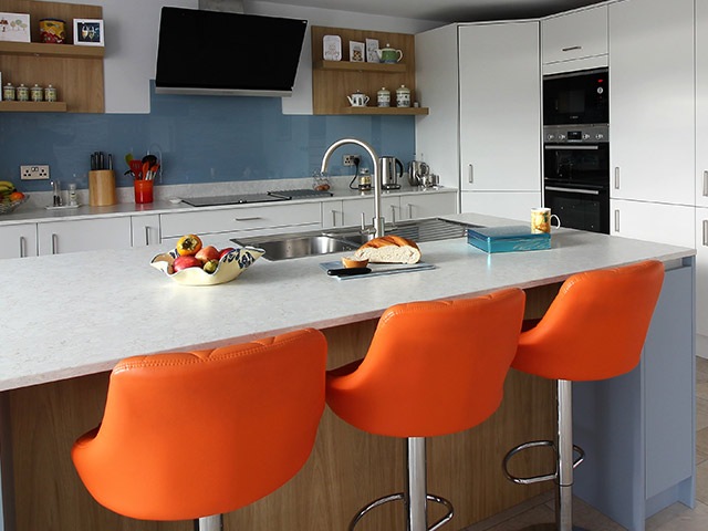 kitchen island with orange bar stools used as breakfast bar