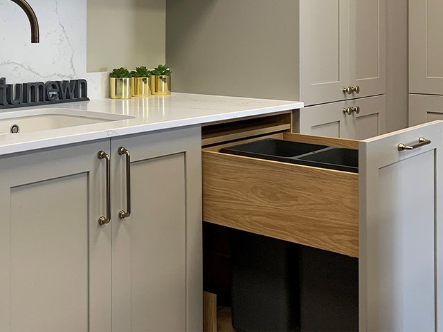 space saving kitchen ideas: a pull out bin in a kitchen is a great way to keep it clutter free