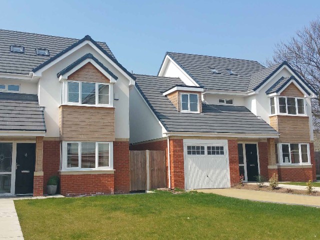 new build homes with square bay windows and pitched roofs