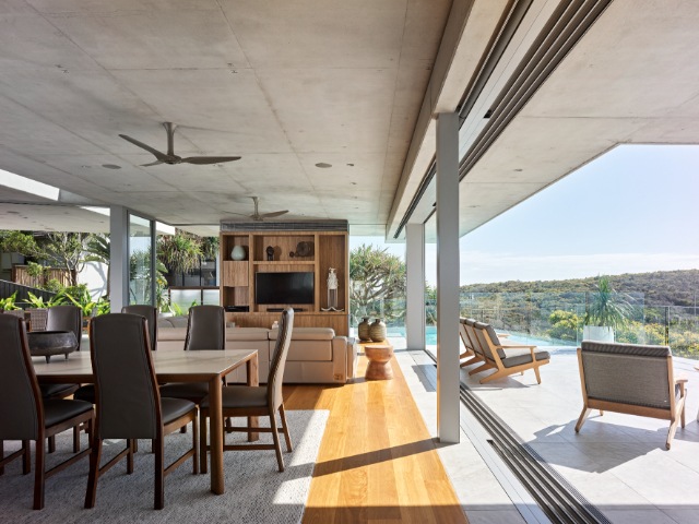 modern home with sliding doors connecting dining room with large terrace area