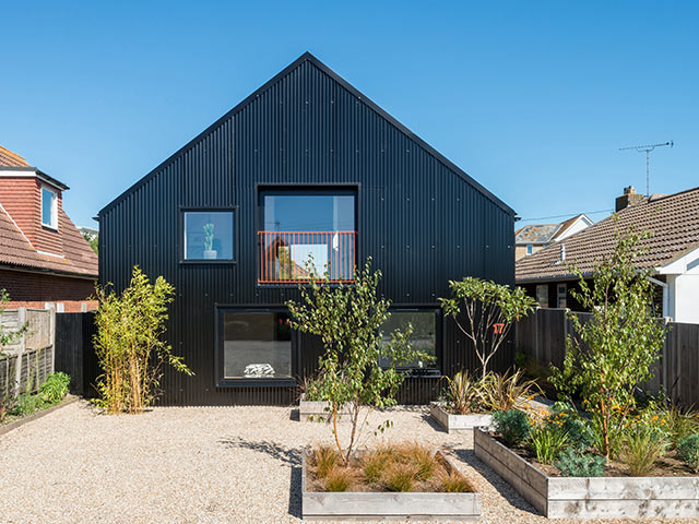 houses under 200k black panelled home with courtyard full of plants