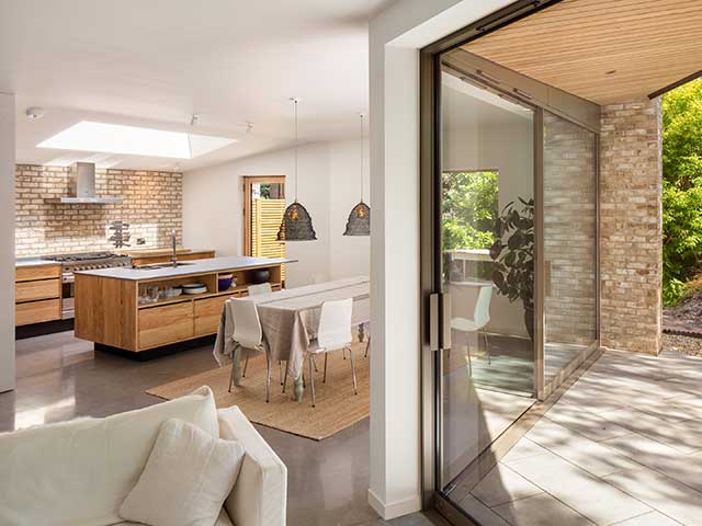 Triangular plot dining room and lounge hold glass sliding doors leading out to the courtyard