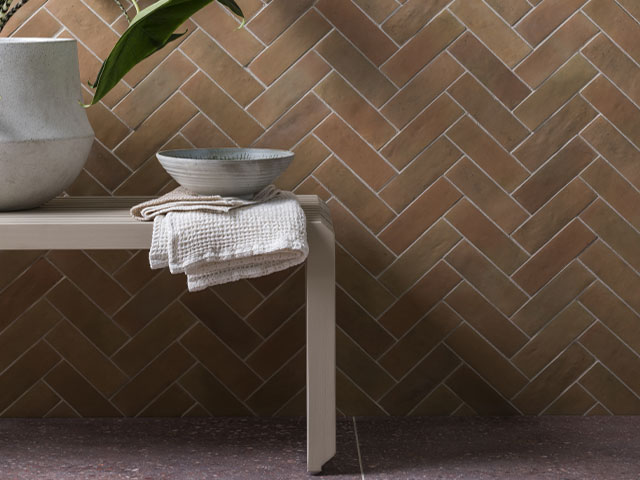 rustic effect shower room tiles in a dark terracotta colour