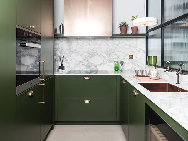 dark green cabinets with pale accent colours, marble splashback and crittall-style windows
