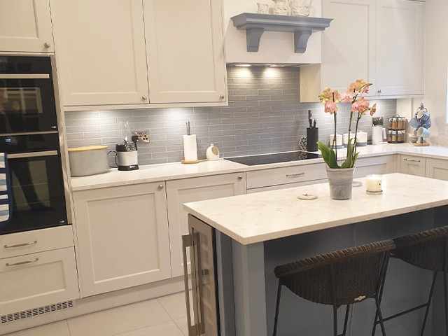 modern kitchen in white and grey with wall cabinets and built-in oven