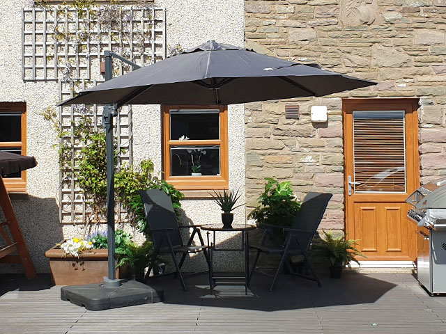 3m terrace umbrella with black canopy over black lounger set