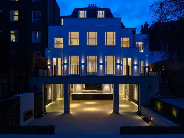 exterior of a London home lit up at night with remodelled open plan lower ground floor 