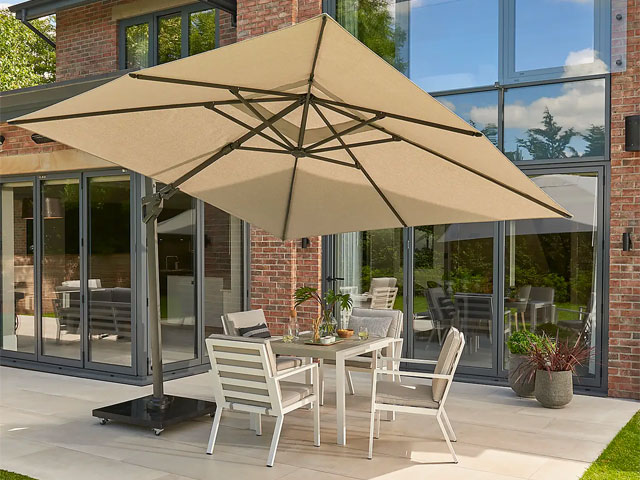 cantilevered parasol with white canopyand grey base over grey and white garden dining set