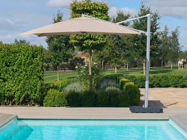 Maze Rattan Zeus cantilever garden umbrella in taupe with round canopy by a swimming pool
