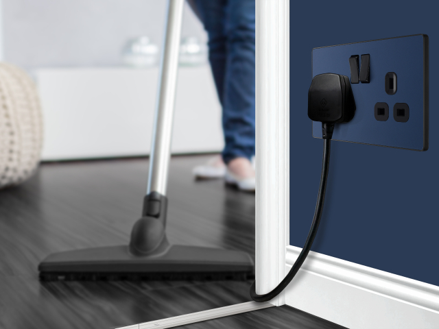 woman hoovering in a modern home with navy walls