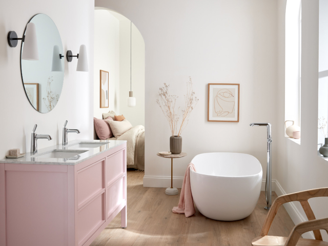 The VADO x Conran Arrondi collection in a family bathroom with white freestanding bath tub and pale pinks cabinets