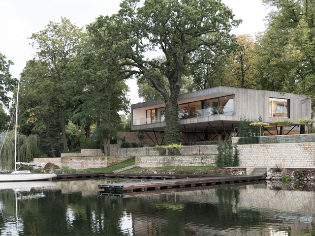 This riverside home by Lake Jungfernsee near Berlin in Germany had to refurbish historic buildings as part of the build