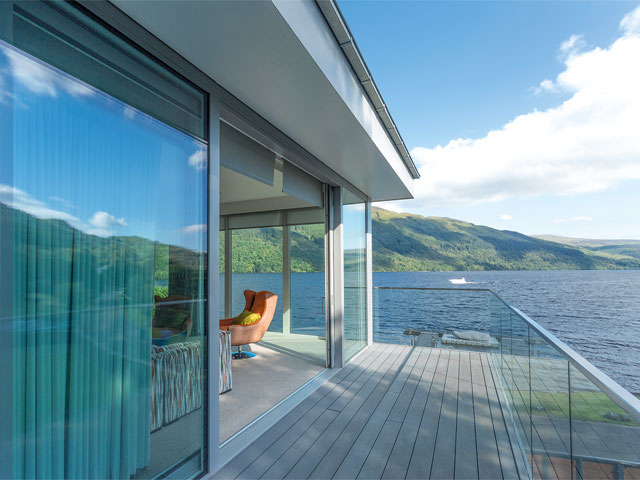 Sandstone house by Loch Lomond with two-storey glazed extension