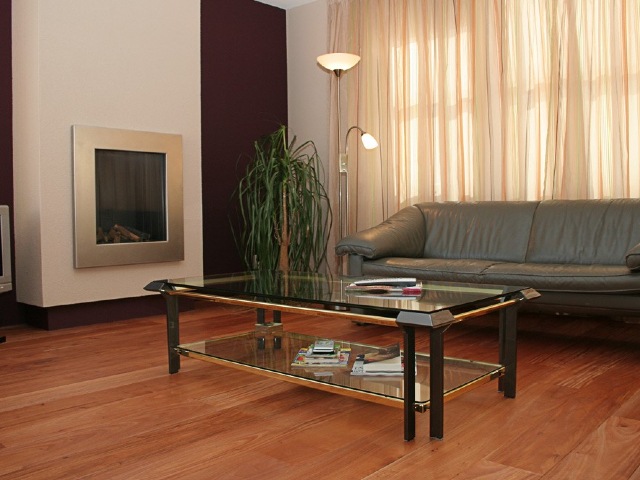 living room with electric fire, grey leather sofa and glass-topped coffee table