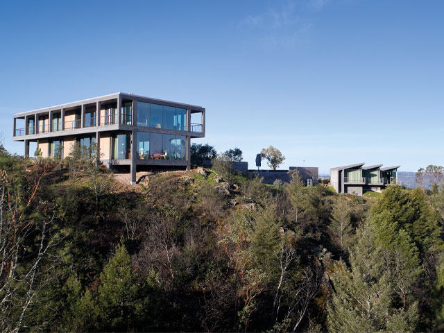 hilltop home in California built on stilts with steel reinforcement with landscaping to prevent soil erosion
