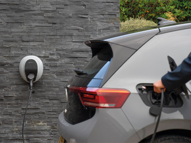 designer home ev smart charger by pod point on a grey slate wall with grey car