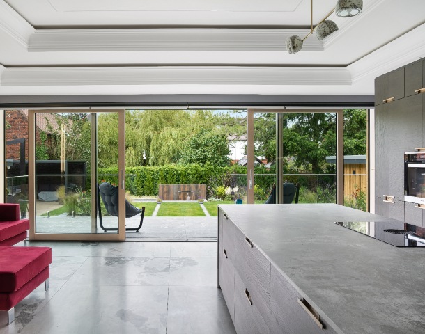 large format grey tiles in a grey kitchen with floor-to-ceiling sliding doors opening onto the garden