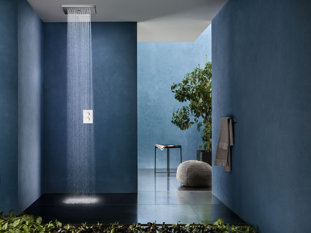 rainfall shower in large bathroom with blue walls and biophilic design