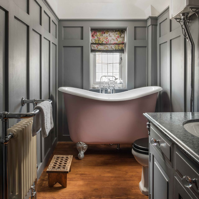 Simple small bathroom ideas - a tubby freestanding bath in a narrow space with grey panelled walls