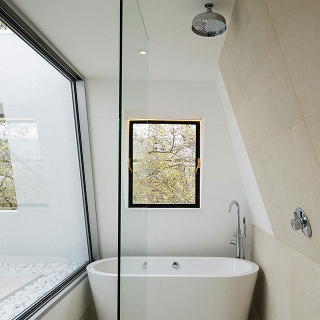 loft conversion bathroom with compact bathtub, walk-through shower and large window