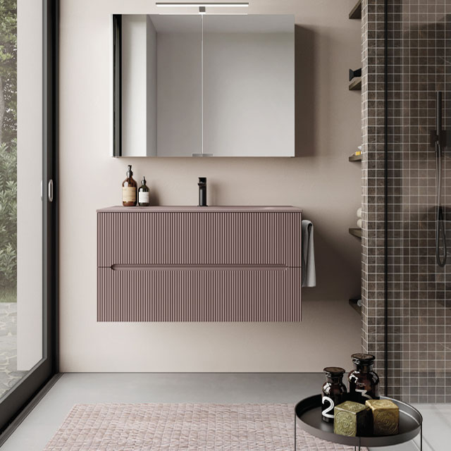 wall mounted vanity unit with mirror cabinet in a wetroom decorated in pale lavender pink with grey tiles and neutral paint